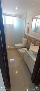 a bathroom with two toilets and a sink and a mirror at Apartamento Acapulco in Punta del Este