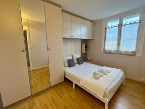 ルマンにあるSuperbe appt 3 ch à 2 pas du circuit des 24Hのタオルが敷かれたベッドのある寝室