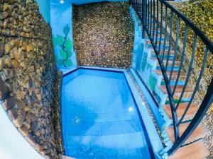 an indoor pool with a rock wall and stairs at Cloudora Inn Kandy in Kandy