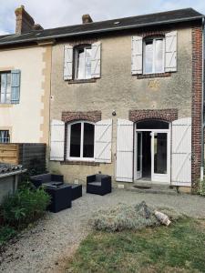 a brick house with windows and a courtyard at Gite Pomme de pin in Almenêches