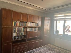 a room with wooden book shelves and a window at Квартира Комфорт in Samarkand