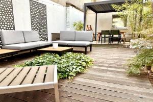 a patio with benches and tables and plants at Maison Arcania Raw Charm & Secret Garden in Reims