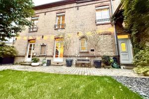 a brick house with a bench in the yard at Maison Arcania Raw Charm & Secret Garden in Reims