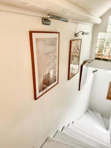 a stairway with two pictures on the wall at Maison Arcania Raw Charm & Secret Garden in Reims