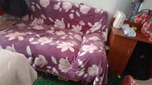a bed with a purple blanket with flowers on it at Гостевой дом Жылдыз Курак in Orto-Saz