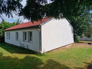 a small white building with a red roof at Bungalow 2 - 4-Raum-Wohnung mit Küche und 2 WC Duschen in Ohrdruf-Crawinkel in Niederdorla