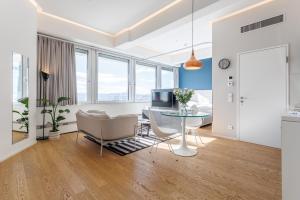 a living room with a table and chairs and a television at Luxury City Apartment with Skyline View in Vienna