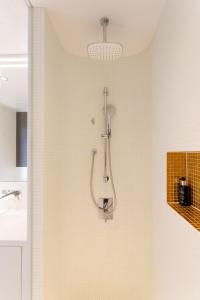 a shower in a bathroom with a shower head at Luxury City Apartment with Skyline View in Vienna