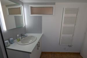a white bathroom with a sink and a mirror at Spacious nest with terrace near the beach in Talmont-Saint-Hilaire +13 photos