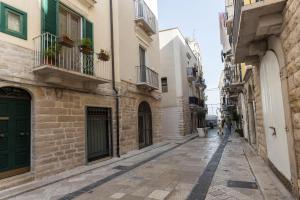 an alley in an old town with people walking down it at B&B Torre Canina suite & rooms in Trani