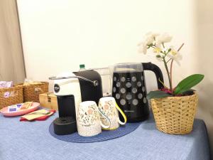 a table with a coffee maker and cups on it at Shine Flowers Room in Scordia