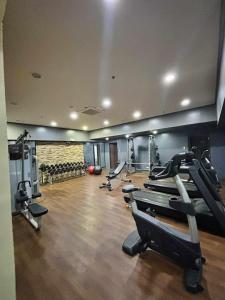 a gym with several treadmills and cardio machines at Suite Escapes Brenthill Baguio 1 Bedroom in Baguio +33 photos