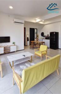 ein Wohnzimmer mit einem gelben Sofa und einem Tisch in der Unterkunft Urban Suites Apartment In Jelutong George Town in George Town