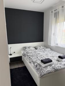 a bedroom with a white bed and a black wall at Kuća za odmor Stubaki in Stubicke Toplice