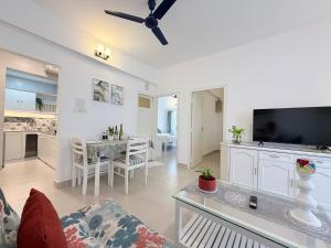 ein Wohnzimmer mit einer Couch, einem Fernseher und einem Tisch in der Unterkunft Vanilla By The Beach Goa in Benaulim