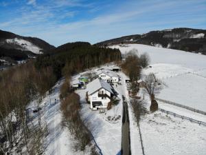 an aerial view of a house in the snow at Dümpelhof Ferienwohnungen in Olsberg