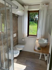 a bathroom with a toilet and a sink and a shower at Trentino Appartamenti Oss in Tenna 