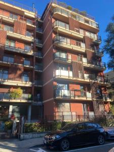 un coche negro estacionado frente a un edificio alto en Suite Del Parco, en Monza