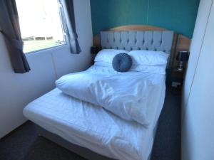 Un dormitorio con una cama con una almohada encima. en Delightful Caravan With A Lake View At Southview Holiday Park Ref 33026Cl, en Winthorpe 9 fotos más