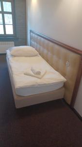 a bed with white sheets and a head board at Zamek Bożejów - Kuźnia in Radomierowice +1 photo