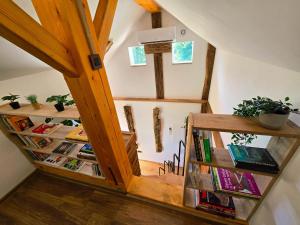 an attic room with bookshelves and a staircase at Vineyard cottage Pri mali luži in Trebelno