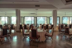 een eetkamer met tafels, stoelen en ramen bij Tamerza Palace By Odyssée 