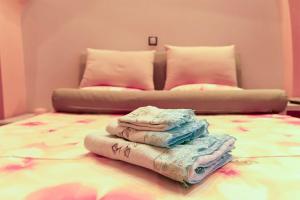 Una pila de toallas encima de una cama en The Sunset Haven Kastoria - Modern Lake Elegance, en Kastoria