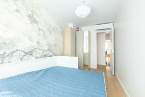 a bedroom with a bed with a blue rug at AK Magnifique et spacieux 3 pièces, vue mer in Antibes