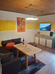 a living room with a table and a couch at Ferienwohnung Herzmensch in Tiefenbach