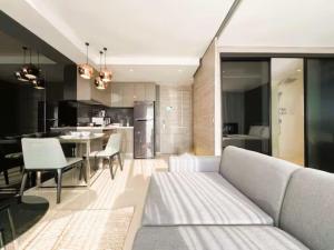 a living room with a couch and a kitchen at Seaphere Residence by Prop Hopper in Na Jomtien +6 photos