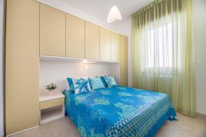 een slaapkamer met een blauw bed en een raam bij Appartamenti Rosa Virginia by Salentoville Gallipoli in Gallipoli +291 foto's