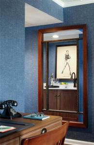 a mirror in a room with a table and a sink at Graduate by Hilton State College in State College