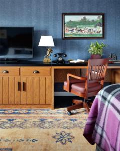 a bedroom with a desk with a television and a chair at Graduate by Hilton State College in State College +56 photos