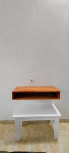 a white bench sitting against a white wall at Mul House Syariah in Bedakah