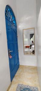 a blue door in a room with a mirror at Mul House Syariah in Bedakah