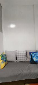 a gray couch in a room with pillows on it at Mul House Syariah in Bedakah