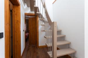 una escalera en una casa con suelo de madera y paredes blancas en Im Kylltal, en Malberg 12 fotos más