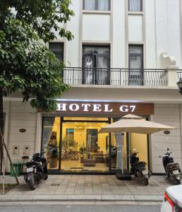 twee motorfietsen staan geparkeerd voor een hotel bij Hotel G7 Ocean Park 2 in Ðình Loan