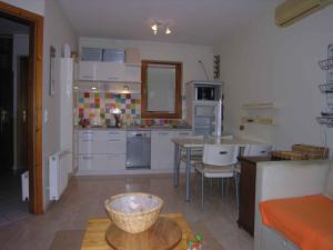 eine Küche mit weißen Schränken, einem Tisch und einer Theke in der Unterkunft Apartment in Balatonlelle 34439 in Balatonlelle + 27 Fotos