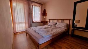 ein Schlafzimmer mit einem Bett in einem Zimmer mit zwei Fenstern in der Unterkunft Apartment in Balatonlelle 34439 in Balatonlelle