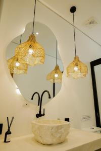 a bathroom with a sink and three lights at Villa Tamu 2 in Bingin Beach