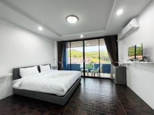 a bedroom with a bed and a large window at At Mutta Lanta House in Ko Lanta Yai