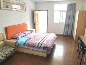 a bedroom with a bed and a desk and a couch at Suhe Homestay in Nanjing