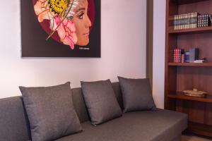 a couch in a living room with a picture on the wall at Terre Saracene Suites - Elegance Near the Central Station in Bitonto