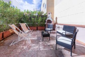 a patio with chairs and a fireplace on a building at Terre Saracene Suites - Elegance Near the Central Station in Bitonto