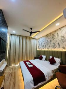een slaapkamer met een bed en een plafondventilator bij The noida heaven in Greater Noida