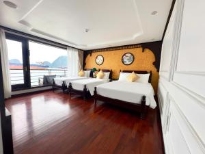 een kamer met vier bedden met klokken aan de muur bij Garden Legend 2 cruise in Ha Long +42 foto's