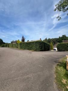 a driveway with a hedge in front of a house at Private Guest House with full kitchen living room and utility room Completely Separate from the Main House in Cobham
