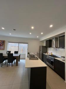 a large kitchen with a table and a dining room at My Home in Truganina