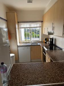 een keuken met houten kasten, een wastafel en een raam bij Casa Bele Algarve in Ferragudo